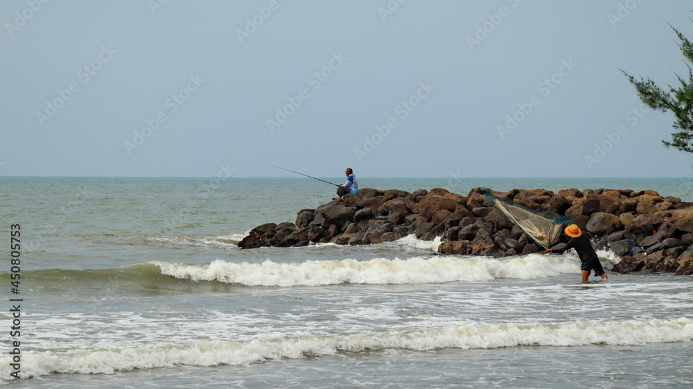 The fisherman caught fish into the net. Hands of fisherman take fish out of a net The fisherman caught fish into the net. Hands of fisherman take fish out of a net