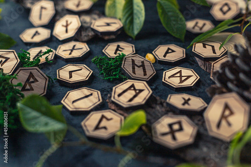 Wooden runes are lying on the table among various objects. Astrology and esotericism. Senior Futhark photo