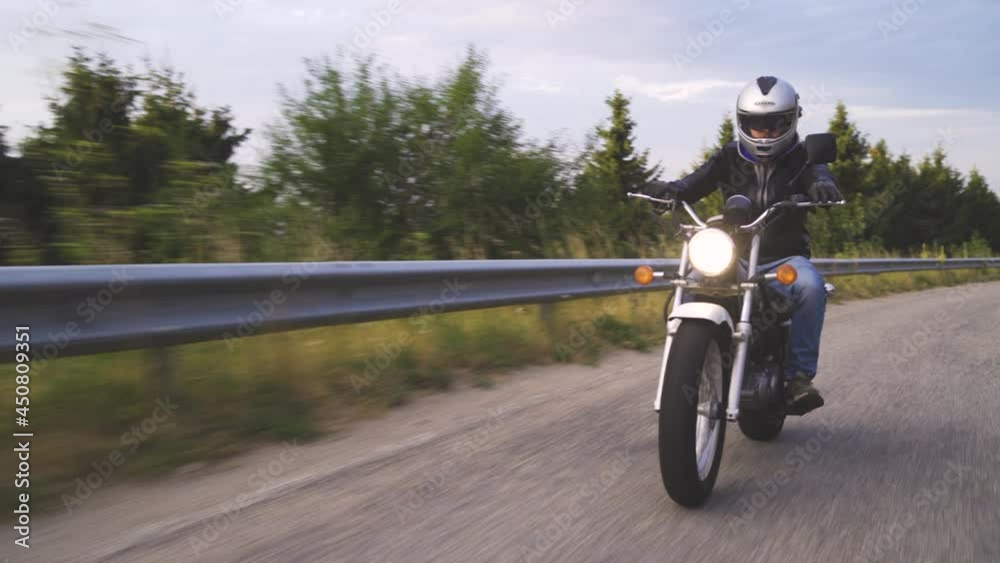 Biker on the forest road riding. having fun driving the empty road on a motorcycle tour journey Biker on the forest road riding. having fun driving the empty road on a motorcycle tour journey