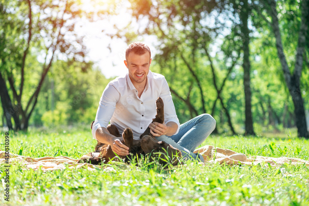 Obraz premium Young man with a dog in the park