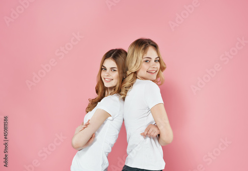 two women in white t-shirts modern summer style friendship emotions pink background