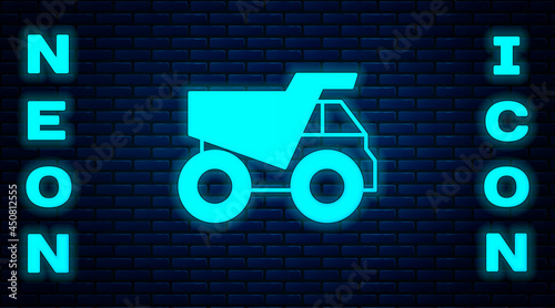 Glowing neon Mining dump truck icon isolated on brick wall background. Vector
