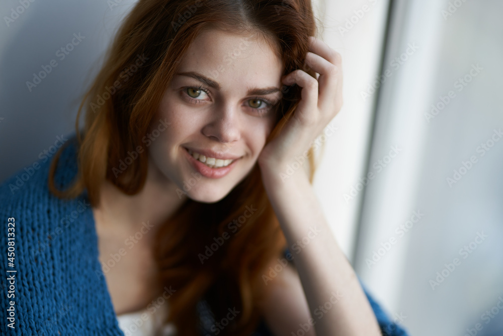 beautiful woman sitting on the windowsill with a blue plaid morning beautiful woman sitting on the windowsill with a blue plaid morning