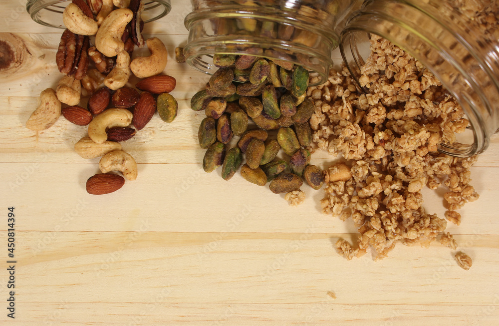 Pistachios and Mixed Nuts With Granola on Wooden Table