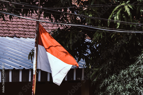 Fototapeta Naklejka Na Ścianę i Meble -  Indonesia Flag Waving in front of house to celebrate Independence Day