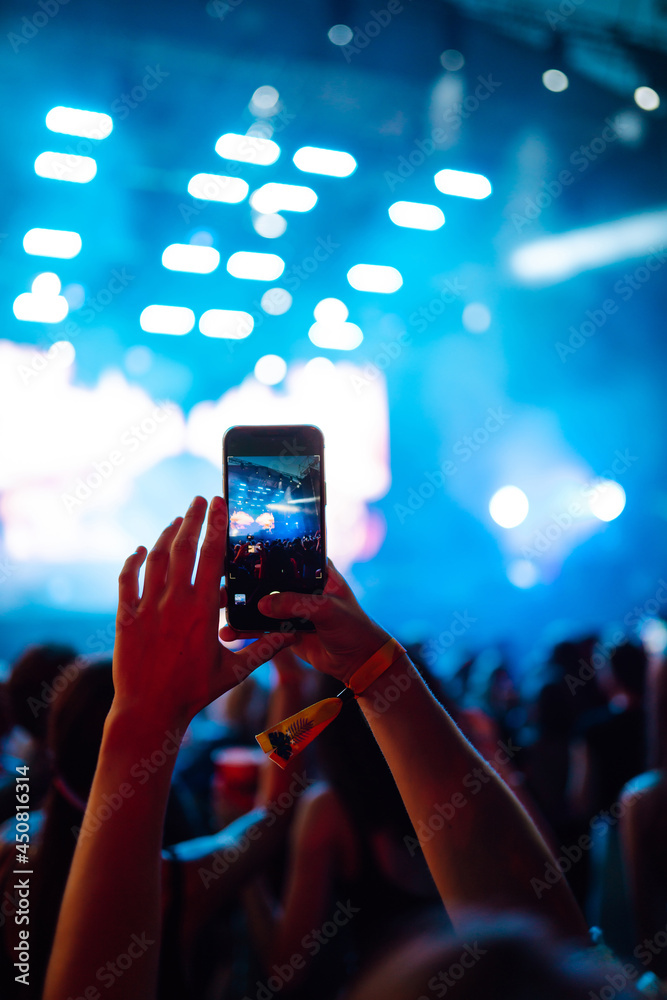 Using a smartphone in a public event, live music festival. Holding a mobile  phone in hands and shooting photo or video content. Youth, party, vacation  concept. Stock Photo | Adobe Stock