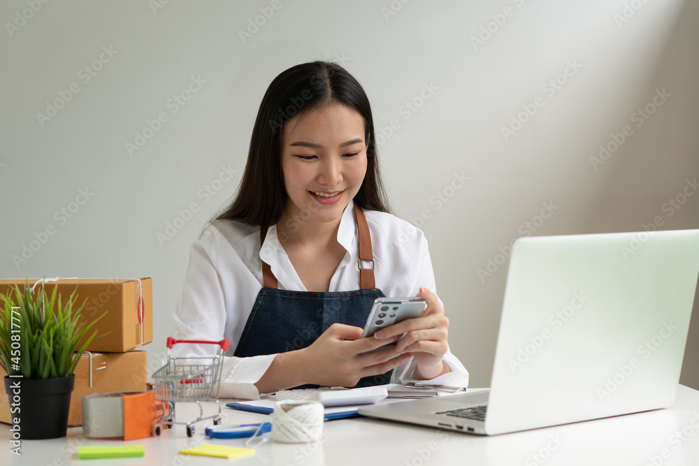 Startup small business entrepreneur SME, young asian woman working with laptop computer and delivery packaging box, online market packing, SME e-commerce seller concept. Startup small business entrepreneur SME, young asian woman working with laptop computer and delivery packaging box, online market packing, SME e-commerce seller concept.