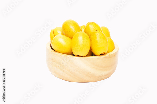 Fresh date fruit yellow gold undried on cup wood (Phoenix dactylifera L. sylvestris) The taste is sweet, crispy, delicious. is becoming popular. Isolated on white background. photo