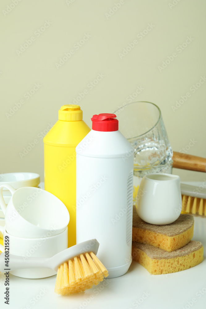 Concept of different Dishwashing detergent accessories on white table Concept of different Dishwashing detergent accessories on white table