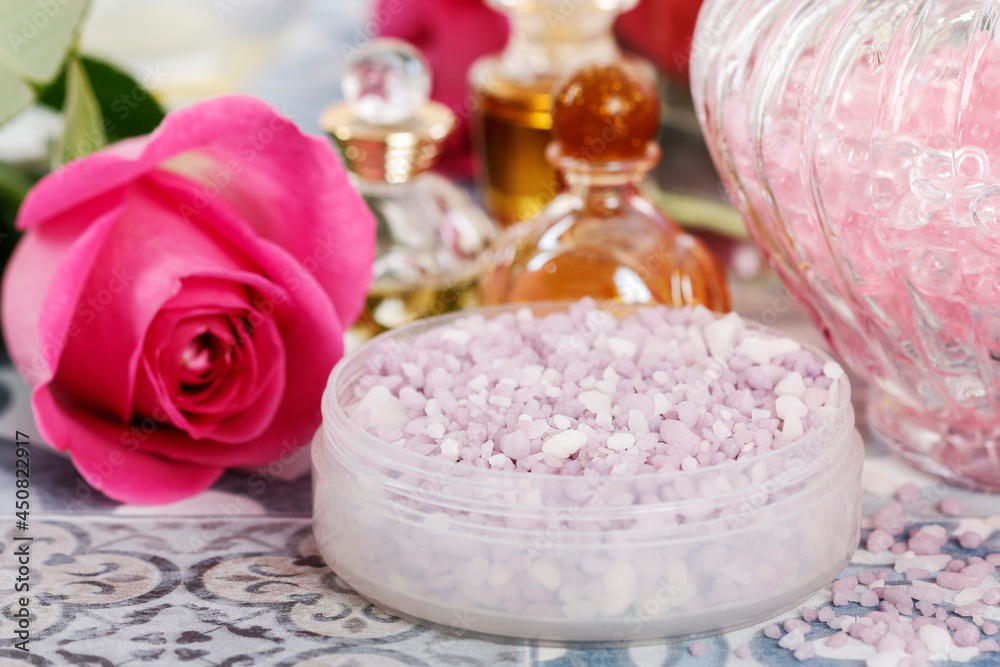 Bowl with a lavender sea salt. Roses and other cosmetics around it.