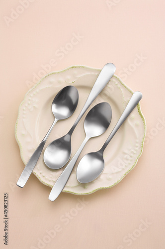spoon in ceramic dish on pastel background