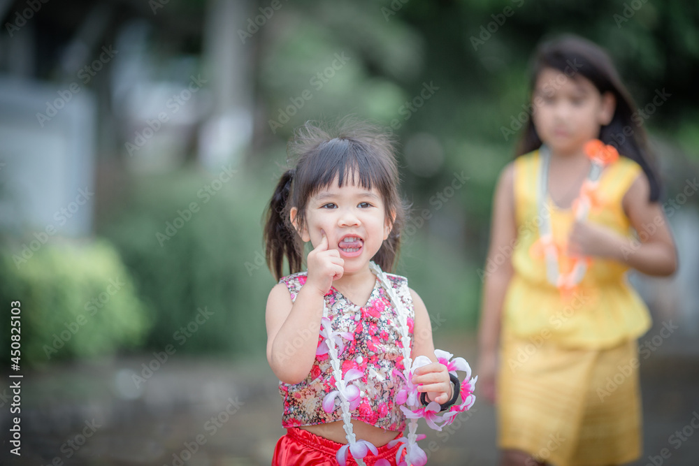 Close-up background view of a blurred Asian girl running or teasing in the street in front of the house, doing activities together outside the classroom during the holidays. Close-up background view of a blurred Asian girl running or teasing in the street in front of the house, doing activities together outside the classroom during the holidays.