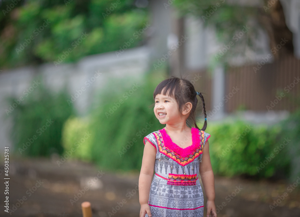 Close-up background view of a blurred Asian girl running or teasing in the street in front of the house, doing activities together outside the classroom during the holidays. Close-up background view of a blurred Asian girl running or teasing in the street in front of the house, doing activities together outside the classroom during the holidays.