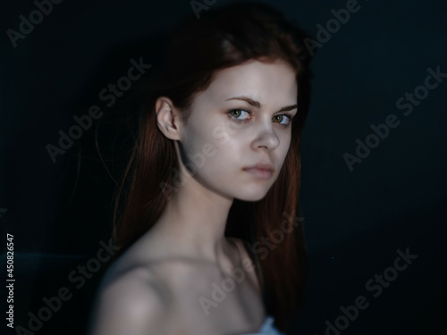 woman with bare shoulders clear skin fashion posing dark background