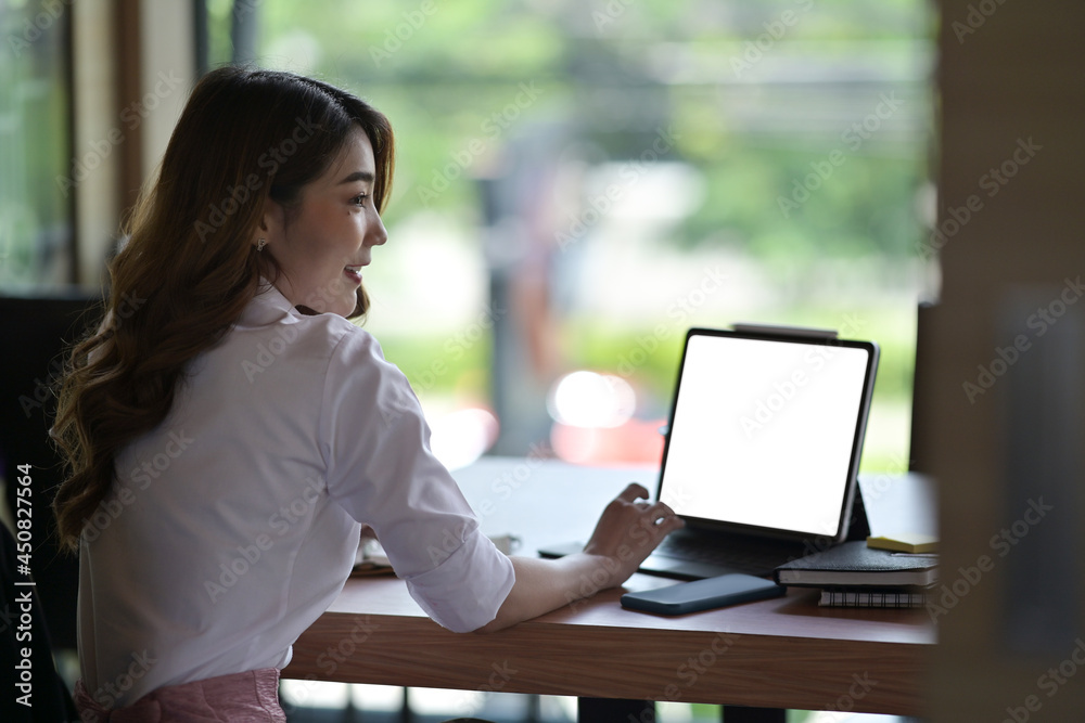 Behind view with Asian businesswoman working with tablet computer on the office desk. Behind view with Asian businesswoman working with tablet computer on the office desk.