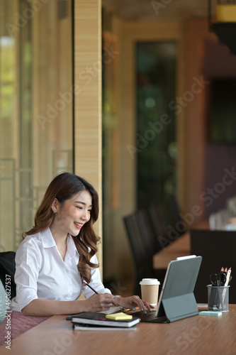 Portrait and side view with businesswoman working on tablet in the meeting room.