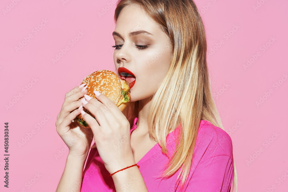pretty woman in pink shirt with hamburger fast food diet