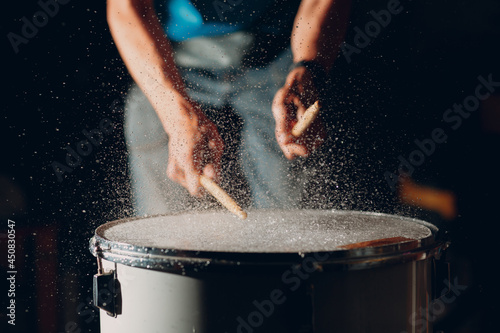 Fotografie Close up drum sticks drumming hit beat rhythm on drum surface with splash water