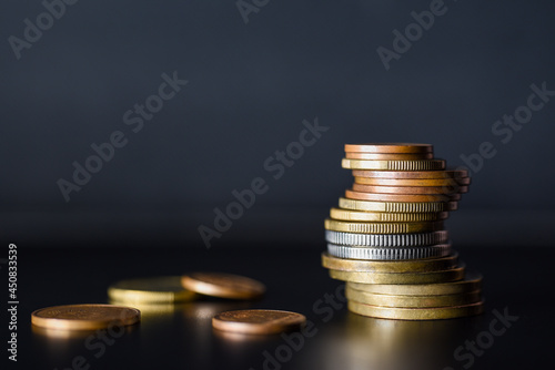 Tower of metal coins on black background