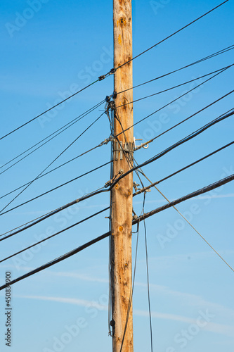 Electric post with several wires over a blue sky