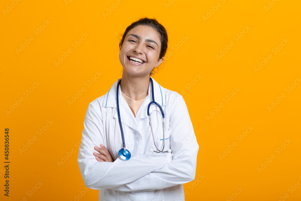 Portrait of ilaughing smiling ndian doctor woman in white medical gown stethoscope isolated on yellow background. Portrait of ilaughing smiling ndian doctor woman in white medical gown stethoscope isolated on yellow background.