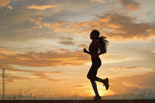 Fototapeta Naklejka Na Ścianę i Meble -  Silhouette young female runing on during sunset