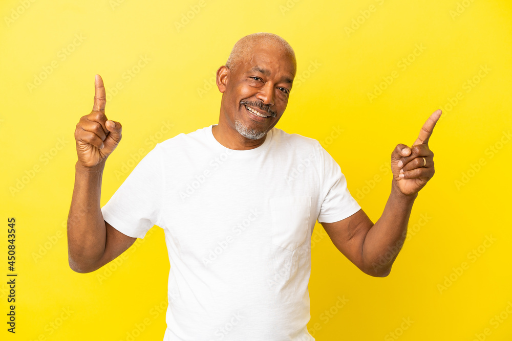 Cuban Senior isolated on yellow background pointing up a great idea Cuban Senior isolated on yellow background pointing up a great idea