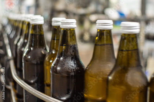 Close-up of 0.5-liter brown glass bottles of water on a conveyor belt