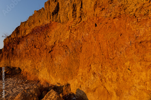 Geology. Desert landscape. Panorama view of the sandstone formation, the rocky cliffs, sand. Background or texture of sandy cliff on the coast, orange limestone