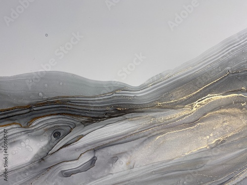 Abstract grey art with gold — black and white background with beautiful smudges and plisse made with alcohol ink and golden paint. Grey fluid texture resembles marble, smoke, watercolor or aquarelle.