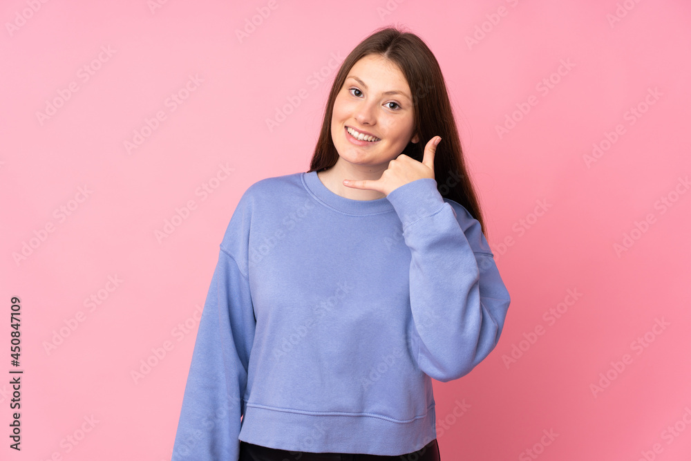 Teenager caucasian girl isolated on pink background making phone gesture. Call me back sign