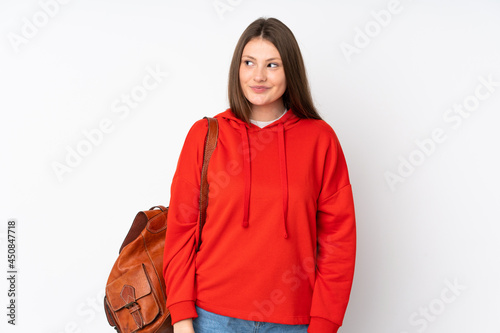 Teenager caucasian student girl isolated on white background standing and looking to the side © luismolinero