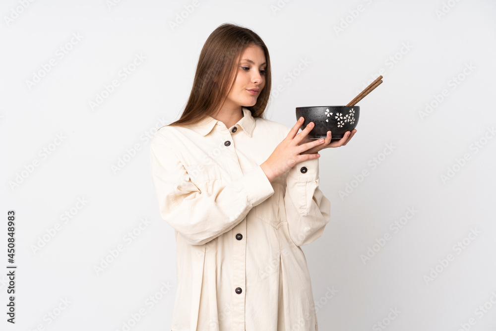 Teenager caucasian girl isolated on white background with happy expression while holding a bowl of noodles with chopsticks Teenager caucasian girl isolated on white background with happy expression while holding a bowl of noodles with chopsticks