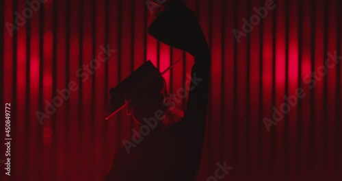 Beautiful hat dressed girl dancing latin dance . Professional female dancer dancing flamenco , rumba or salsa on red background with lines . Spanish dance movements . Shot ARRI ALEXA Cinema Camera .