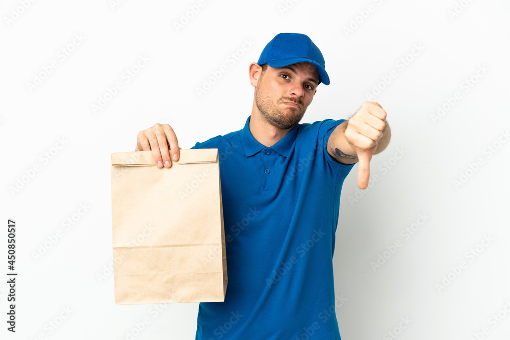 Brazilian taking a bag of takeaway food isolated on white background showing thumb down with negative expression Brazilian taking a bag of takeaway food isolated on white background showing thumb down with negative expression