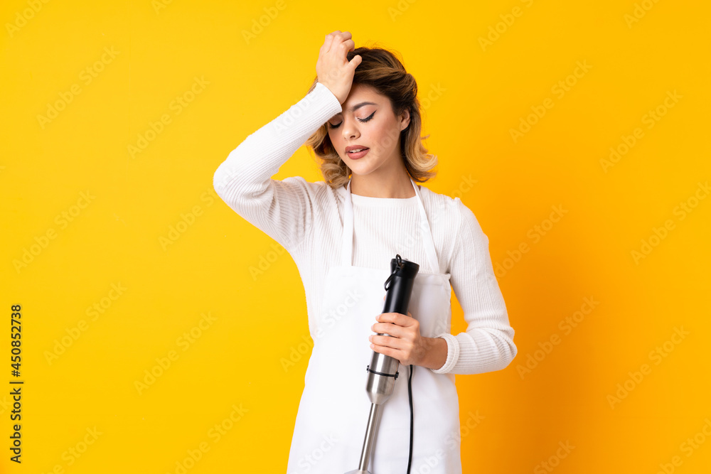 Girl using hand blender isolated on yellow background has realized something and intending the solution