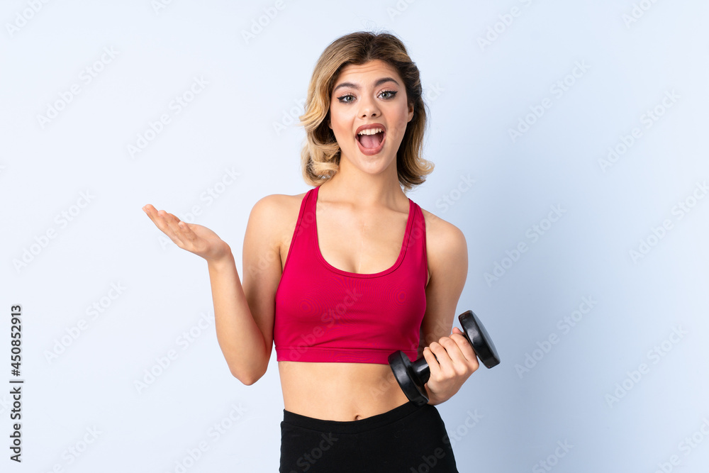 Teenager Russian girl making weightlifting isolated on blue background with shocked facial expression Teenager Russian girl making weightlifting isolated on blue background with shocked facial expression