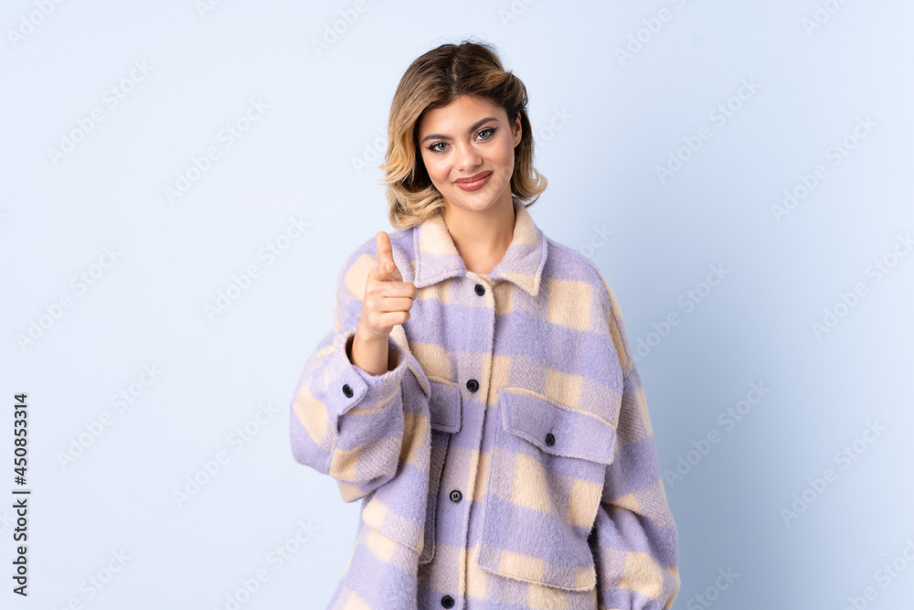 Young Russian woman isolated on blue background pointing front with happy expression Young Russian woman isolated on blue background pointing front with happy expression