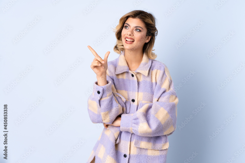 Young Russian woman isolated on blue background pointing to the side to present a product Young Russian woman isolated on blue background pointing to the side to present a product