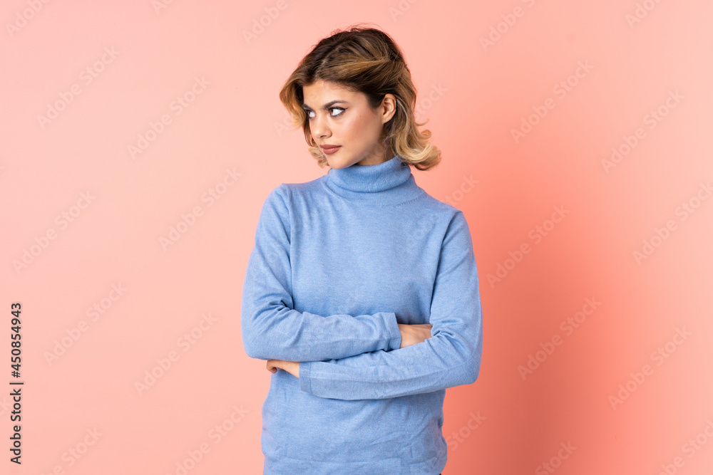 Young Russian woman isolated on pink background keeping the arms crossed