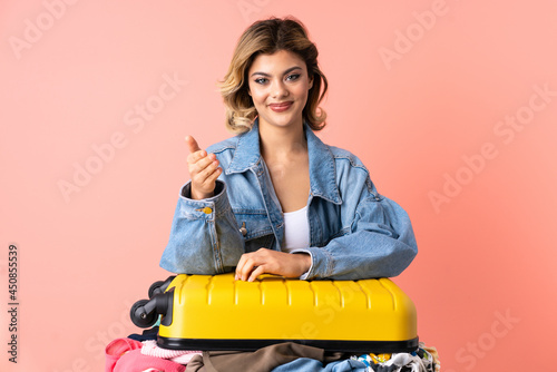 Teenager woman with salad isolated on blue background shaking hands for closing a good deal