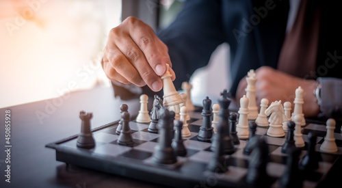 Close up businessman play chess board game.White chess team and black chess team idea for business competition and team work.