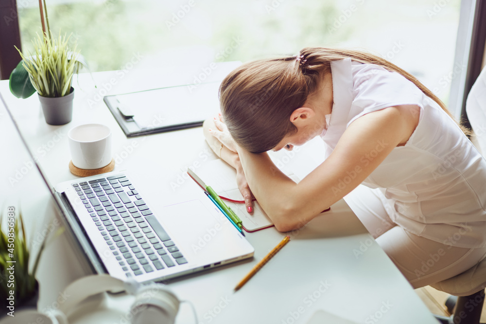 Obraz premium Work is done coffee break. Overworked and tired young business woman sleeping on desk at work in her office. Entrepreneur, business, freelance work, student, stress, work from home concept