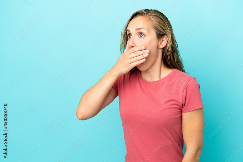 Young caucasian woman isolated on blue background doing surprise gesture while looking to the side Young caucasian woman isolated on blue background doing surprise gesture while looking to the side