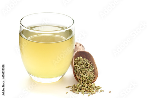 Close-Up of original  organic boiled water (Tea or kada ) with Sonf  or Fennel seed ( Foeniculum vulgare ) in a transparent glass cup over white background. Original residue in bottom of tea cup photo