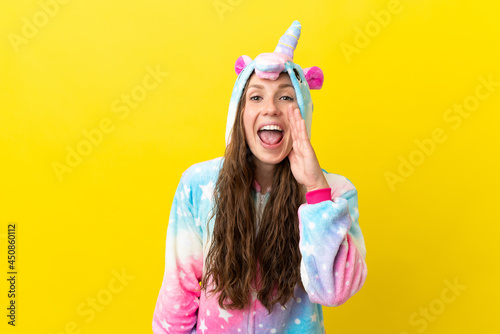 Girl with unicorn pajamas over isolated background shouting with mouth wide open