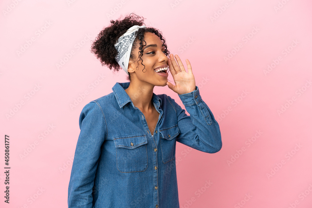 Young latin woman isolated on pink background shouting with mouth wide open to the side Young latin woman isolated on pink background shouting with mouth wide open to the side