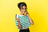 Young african american woman isolated on yellow background keeping a conversation with the mobile phone and holding a credit card