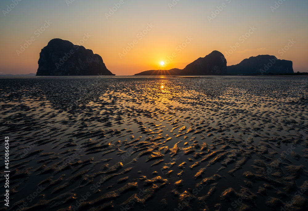 Sand waves texture with reflection of sunset on the Pak Meng beach, Trang, Thailand