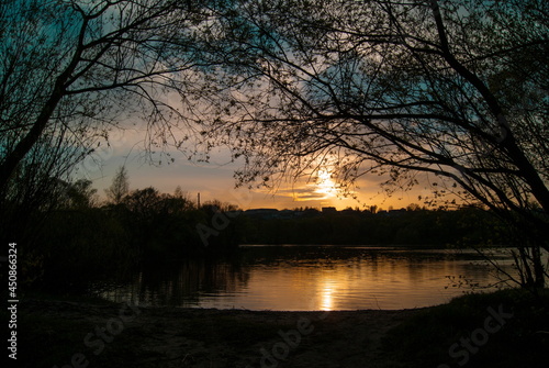 The sun sets over a forest lake © Arina